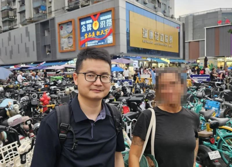 Lee and his customers at the clothing market.
