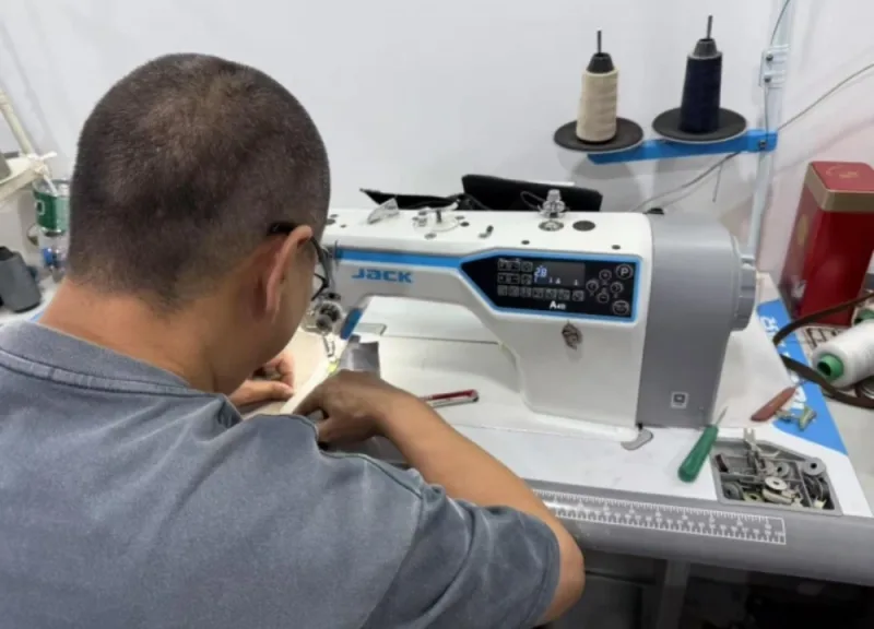 Textile Factory Worker Operating Industrial Sewing Machine for Garment Stitching