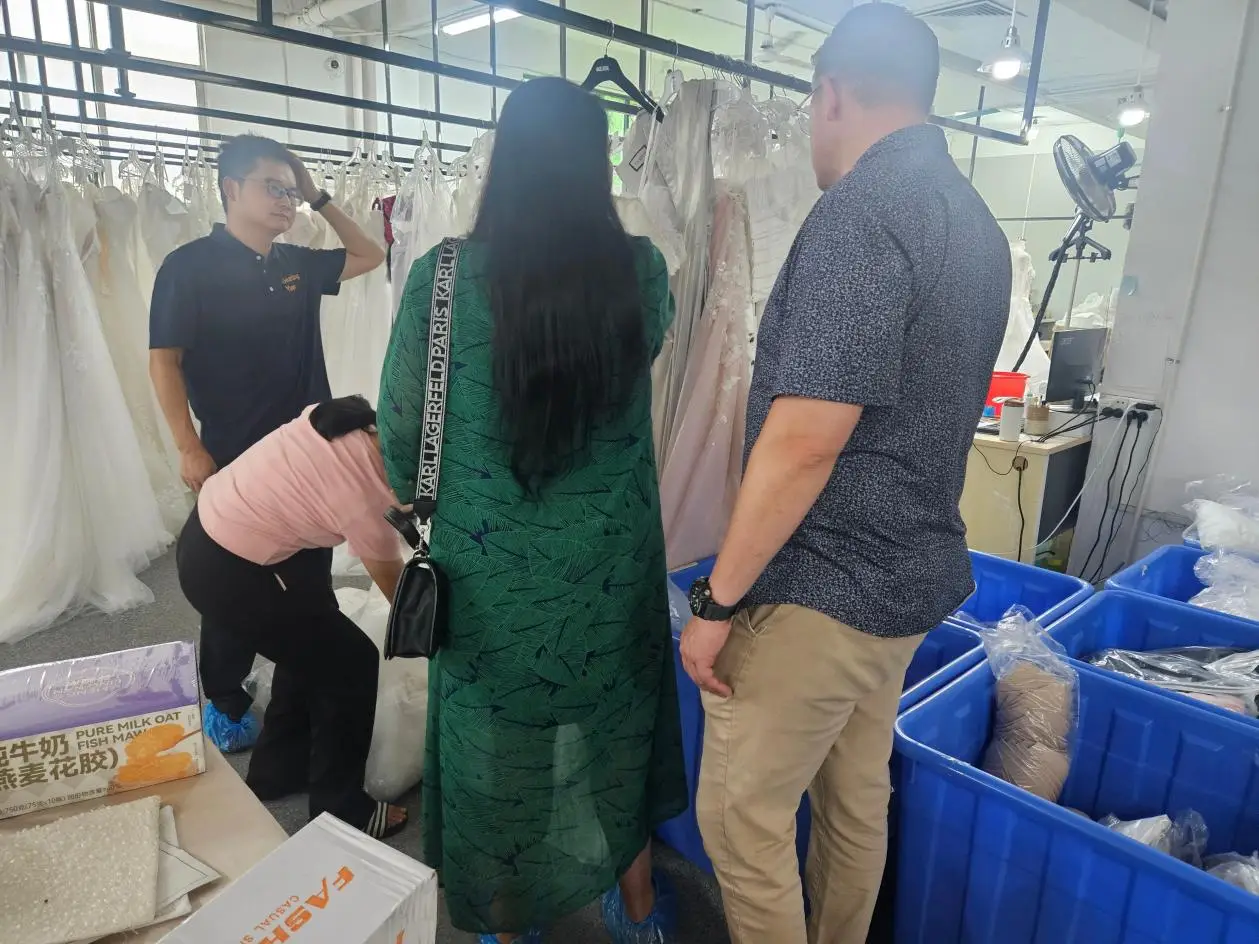 Accompanying a client on a tour of the wedding dress factory workshop Accompanying a client on a tour of the wedding dress factory workshop