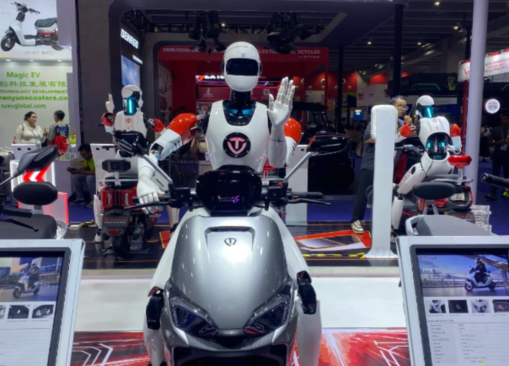 Humanoid service robot beside electric vehicle booth Humanoid service robot beside electric vehicle booth